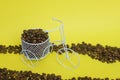 Closeup of a funny bicycle bowl with coffee beans on a yellow background Royalty Free Stock Photo