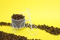 Closeup of a funny bicycle bowl with coffee beans on a yellow background Royalty Free Stock Photo