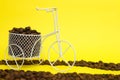 Closeup of a funny bicycle bowl with coffee beans on a yellow background Royalty Free Stock Photo