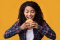 Closeup Of Funny Black Woman Eating Burger At Orange Studio Royalty Free Stock Photo