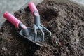 Closeup gardening tools on the fertile soil. Leisure activity in organic farming