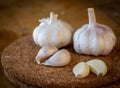 Closeup of garlic bulb and cloves on a round cork board Royalty Free Stock Photo