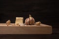 Closeup of garlic cloves and butter on a wooden board under the lights