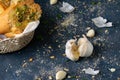 Closeup garlic cloves and herbed bread on a gray table