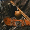 closeup of gaucho mate yerba mate elements with bombilla rebenque leather belt with chain and silver logo and spur,raota-argentina