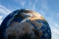 Closeup of a giant model of the Earth against a blue sky in Brno Observatory and Planetarium