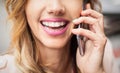 Closeup of girl with beautiful teeth, talking on her smartphone Royalty Free Stock Photo