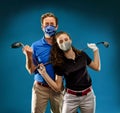 Girl and a boy playing golf with Covid-19 mask, they are ready to go