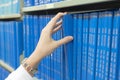 Closeup girl hand selecting book from a bookshelf