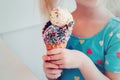 Caucasian blonde preschool girl child with blue eyes holding ice cream in large waffle cone Royalty Free Stock Photo