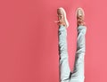 Closeup girl kid legs in jeans and sneakers on pink Royalty Free Stock Photo