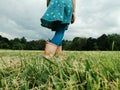 Closeup of girl legs feet in rain boots walking on meadow. Freedom, innocence and adolescense concept. Summer fun outdoors Royalty Free Stock Photo