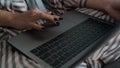 Closeup girl using laptop browsing internet in pajamas. Hand touching device pad