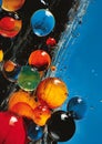 Closeup of glass balls floating in deep, glossy magazine liquid