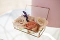 Close up glass box for wedding rings decorated with fresh rose flowers and banch of lavender. Event decoration with fresh flowers Royalty Free Stock Photo