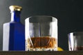 Closeup of glass of brandy against bottle and other glass, lemon.Low angle photo Royalty Free Stock Photo