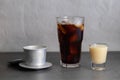 Closeup of a glass of iced coffee, condensed milk and a Vietnamese coffee filter