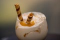 Closeup of a glass of milkshake under the lights with a blurry background