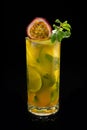 Closeup glass of Mojito with passion fruit lime and green leaf mint isolated on black background. Royalty Free Stock Photo