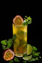 Mojito with passion fruit  maracuya  lime and green leaf mint isolated on black background Royalty Free Stock Photo