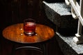 Closeup glass of negroni cocktail with ice at bar table at porch stairs background