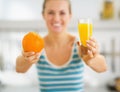 Closeup on glass of orange juice and orange in hand of woman Royalty Free Stock Photo