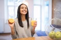 Closeup on glass of orange juice and orange in hand of young woman at kitchen Royalty Free Stock Photo