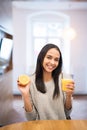 Closeup on glass of orange juice and orange in hand of young woman at kitchen Royalty Free Stock Photo