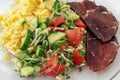 Closeup glass plate with complete diet meal. Slice of smoked meat, vegetable salad with microgreens, sprouts of cereals and brocco