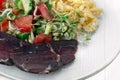 Closeup glass plate with complete diet meal. Slice of smoked meat, vegetable salad with microgreens, sprouts of cereals and green