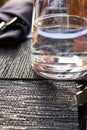 Closeup of a glass of purified fresh drinking water without gas on a table with a reflective surface with a napkin and cutlery. Royalty Free Stock Photo