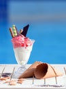 Closeup of glass with vanilla, watermelon ice cream on blur bokeh background with copy space. Cherry berries sorbet with waffle Royalty Free Stock Photo