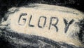 Closeup of GLORY word written on white sand Royalty Free Stock Photo
