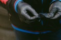 Closeup of a gloved worked opening a radial tire patch in a workshop