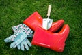 Closeup of gloves, gumboots and shovel on green grass Royalty Free Stock Photo