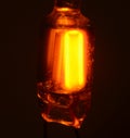 Closeup of glow lamp on dark background, the lamp is supplied with direct current. Only the negetive electrode emits light