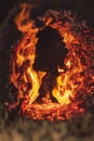 Closeup of glowing log embers and flames creating a fiery abstract background