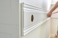 Closeup of gluing wooden white painted plank panel on wall, closeup, carpentry, woodwork, profession, people