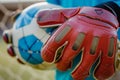 closeup of goalkeeper gloves holding a soccer ball Royalty Free Stock Photo