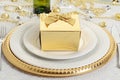 Closeup gold gift with table setting Royalty Free Stock Photo