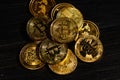 Closeup golden coin with bitcoin logo. Leader in cryptocurrency Bitcoin BTC on a top of coins against black wooden surface. Pile