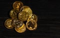 Closeup golden coin with bitcoin logo. Leader in cryptocurrency Bitcoin BTC on a top of coins against black wooden surface. Pile