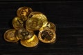 Closeup golden coin with bitcoin logo. Leader in cryptocurrency Bitcoin BTC on a top of coins against black wooden surface. Pile