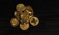 Closeup golden coin with bitcoin logo. Leader in cryptocurrency Bitcoin BTC on a top of coins against black wooden surface. Pile