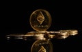 Closeup golden coin with Ether logo. New cryptocurrency Ethereum ETH 2.0 on a top of bitcoin coins against black background. A