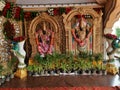 Closeup of Golden Color Lord Venkateshwara and his wife Goddess Lakshmi Statue at the entrance of Wedding Hall or Kalyana Mantapa