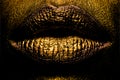 Closeup golden lips closeup. Gold metal lip. Beautiful makeup. Golden lip gloss on beauty female mouth, closeup. Sensual