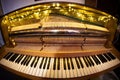 Closeup of a golden piano illuminated by lights