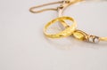 Closeup golden ring and gold bracelet on blurred gray marble stone floor background