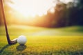 Closeup golf club and golf ball on green grass at sunset Royalty Free Stock Photo